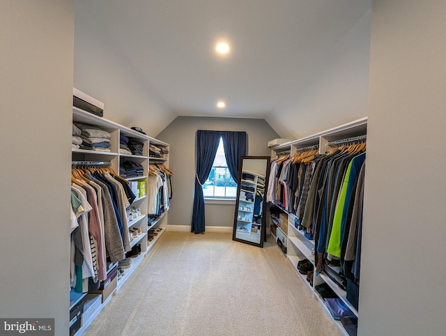 walk in closet featuring vaulted ceiling and light carpet