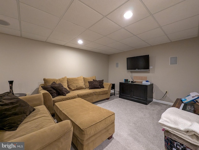 carpeted living room with a drop ceiling