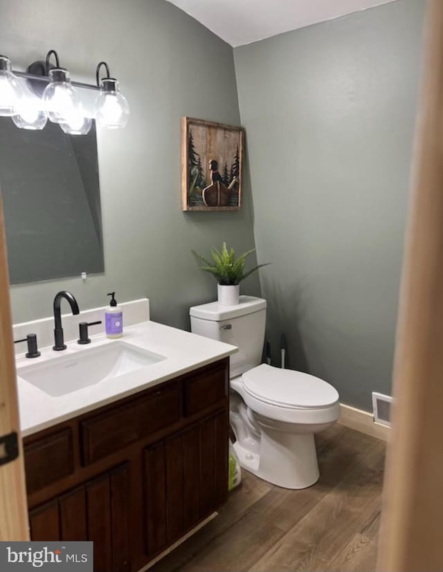 bathroom with vanity, hardwood / wood-style flooring, and toilet