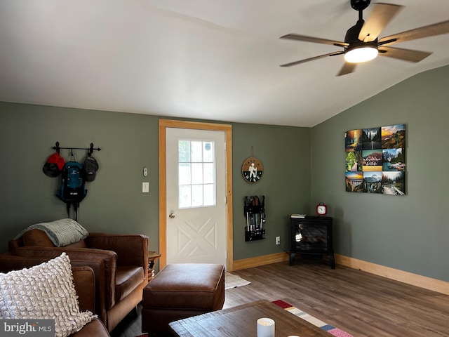 living room with a wood stove, ceiling fan, lofted ceiling, and hardwood / wood-style flooring