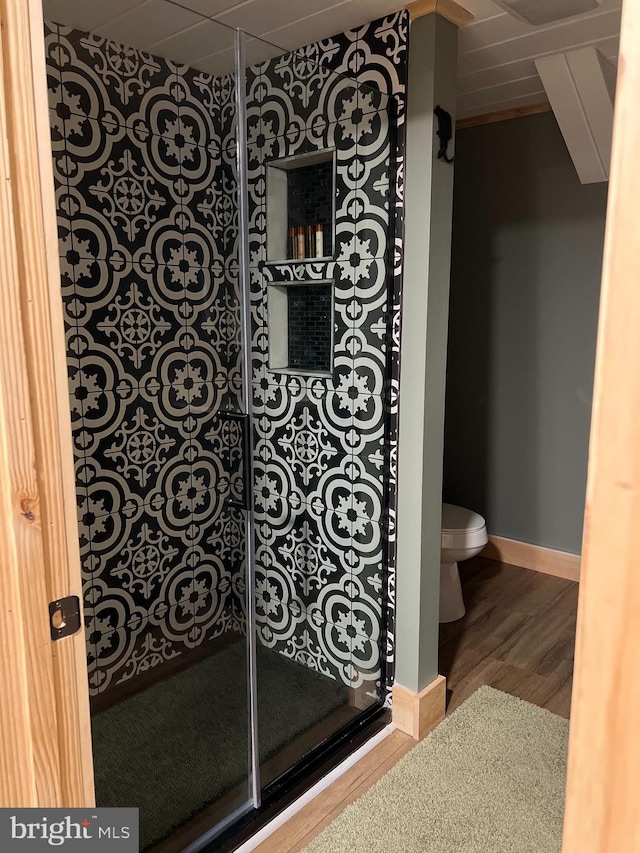 bathroom featuring wood-type flooring, toilet, and walk in shower