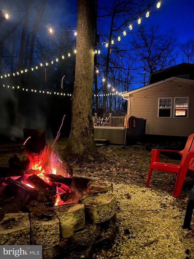 yard at night featuring a wooden deck