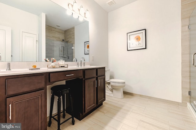 bathroom with toilet, vanity, tile patterned flooring, and a shower with shower door