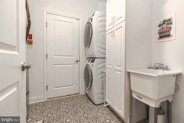 laundry room featuring sink and stacked washer / drying machine