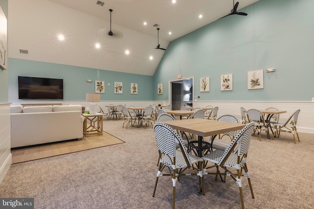 dining area featuring high vaulted ceiling and carpet flooring