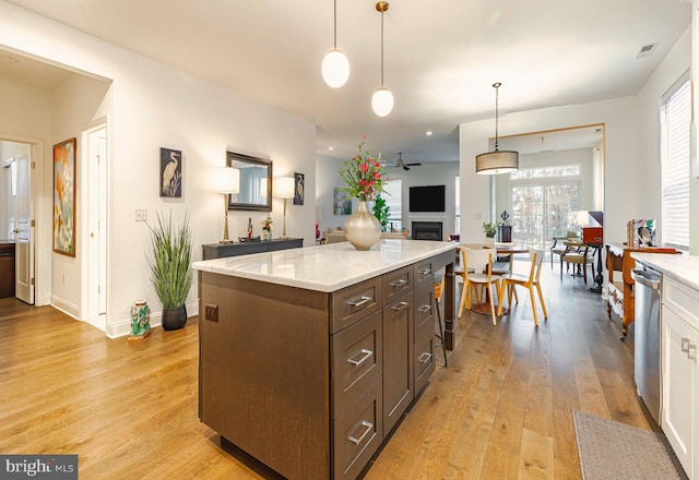 kitchen featuring ceiling fan, a healthy amount of sunlight, light hardwood / wood-style flooring, and decorative light fixtures