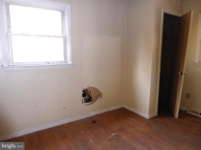 spare room with hardwood / wood-style floors and a healthy amount of sunlight