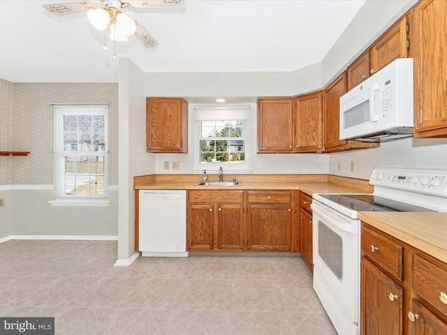 kitchen featuring sink, white appliances, and ceiling fan