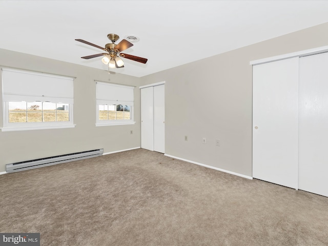 unfurnished bedroom featuring light carpet, two closets, a baseboard radiator, and ceiling fan