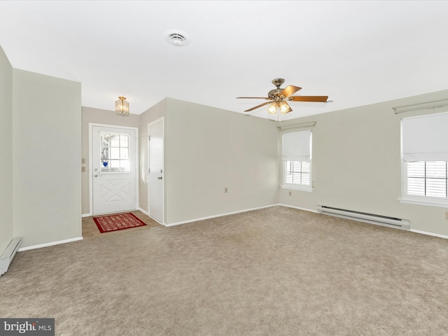 carpeted foyer entrance with a baseboard radiator, ceiling fan, and plenty of natural light