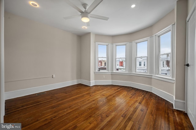 unfurnished room featuring ceiling fan and dark wood-type flooring