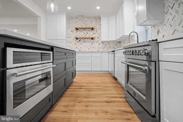 kitchen with white cabinets, decorative backsplash, and appliances with stainless steel finishes