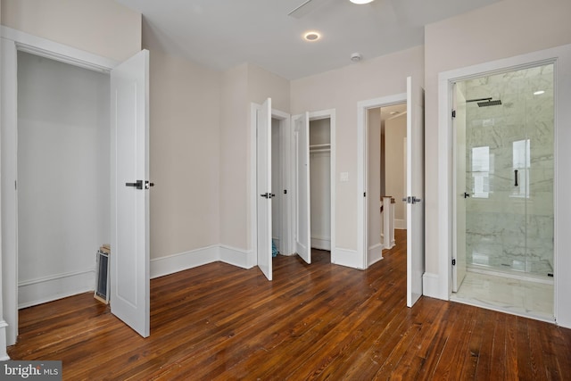 unfurnished bedroom with ceiling fan, dark hardwood / wood-style flooring, and connected bathroom