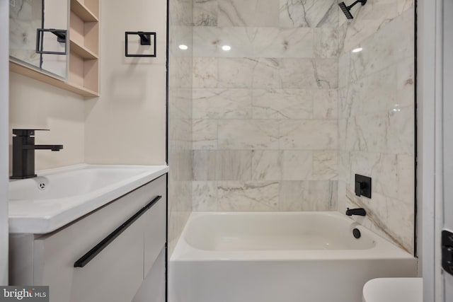 full bathroom featuring toilet, vanity, and tiled shower / bath