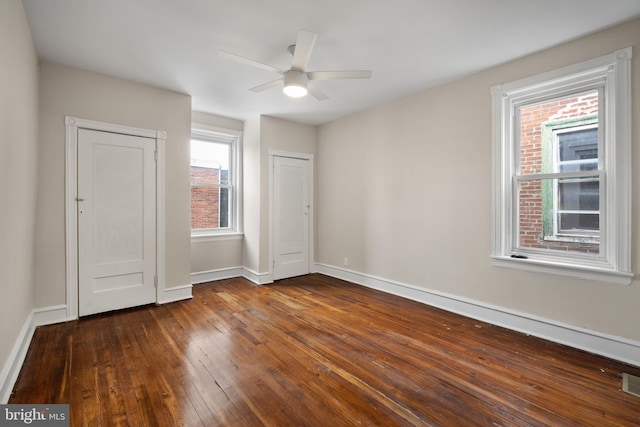 unfurnished bedroom featuring ceiling fan and dark hardwood / wood-style flooring