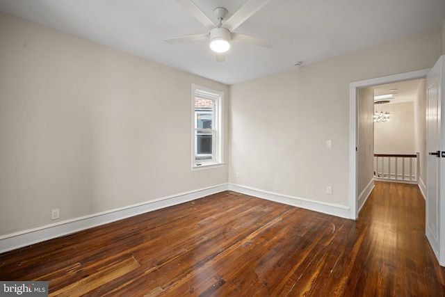 spare room with dark hardwood / wood-style flooring and ceiling fan