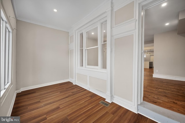 interior space with ornamental molding and dark wood-type flooring