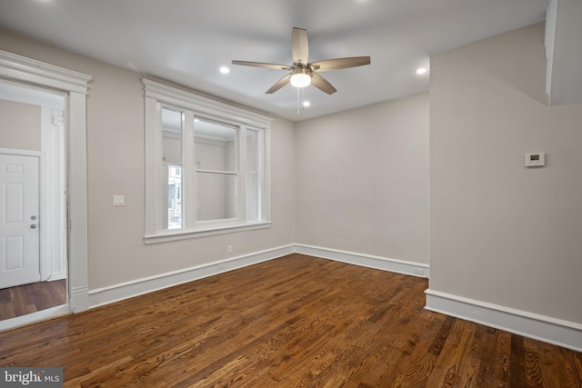 unfurnished room featuring ceiling fan and dark wood-type flooring