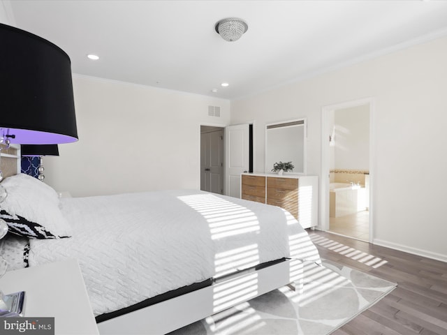 bedroom with hardwood / wood-style floors, connected bathroom, and ornamental molding