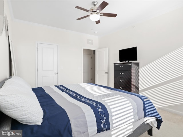 carpeted bedroom with ceiling fan and ornamental molding