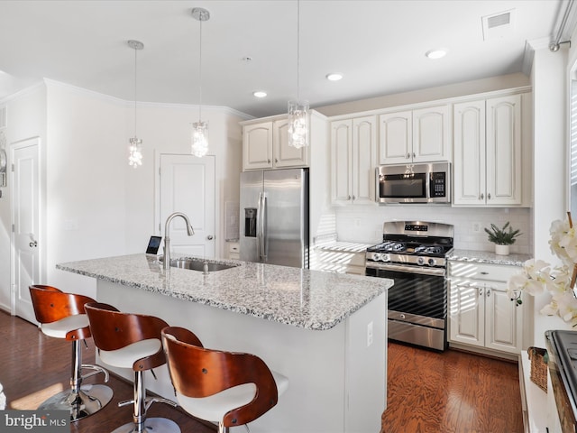 kitchen featuring appliances with stainless steel finishes, light stone countertops, pendant lighting, sink, and backsplash