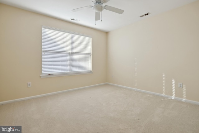 carpeted spare room featuring ceiling fan