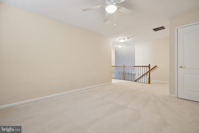 spare room featuring ceiling fan and light carpet