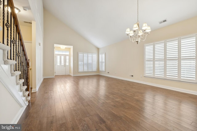 unfurnished living room with a notable chandelier, dark hardwood / wood-style floors, and plenty of natural light