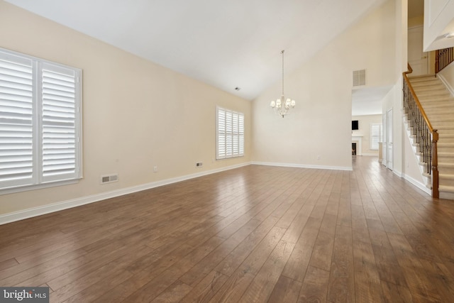 interior space with high vaulted ceiling, dark hardwood / wood-style flooring, and a notable chandelier