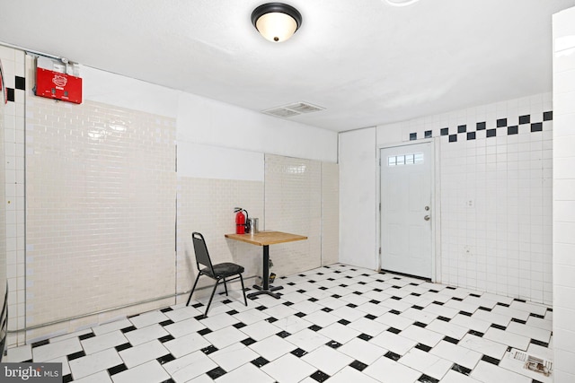 foyer featuring tile walls