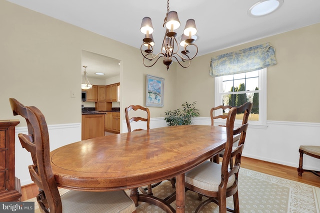 dining area featuring light hardwood / wood-style floors and an inviting chandelier