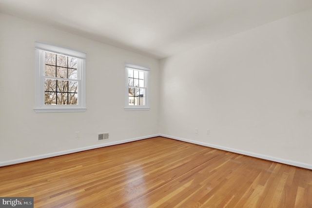 empty room with a healthy amount of sunlight and light hardwood / wood-style flooring