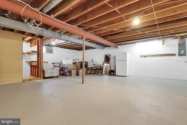 basement with electric panel and white fridge