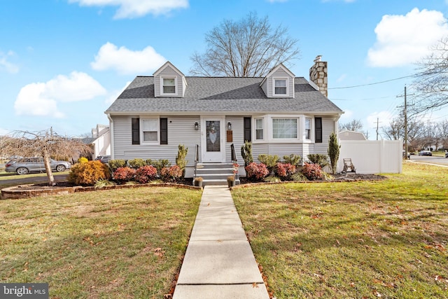 cape cod-style house featuring a shingled roof, a chimney, and a front lawn