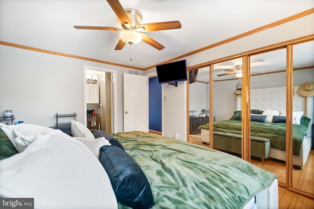 bedroom with crown molding, hardwood / wood-style flooring, and ceiling fan