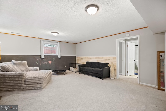 sitting room featuring carpet floors, a textured ceiling, and ornamental molding