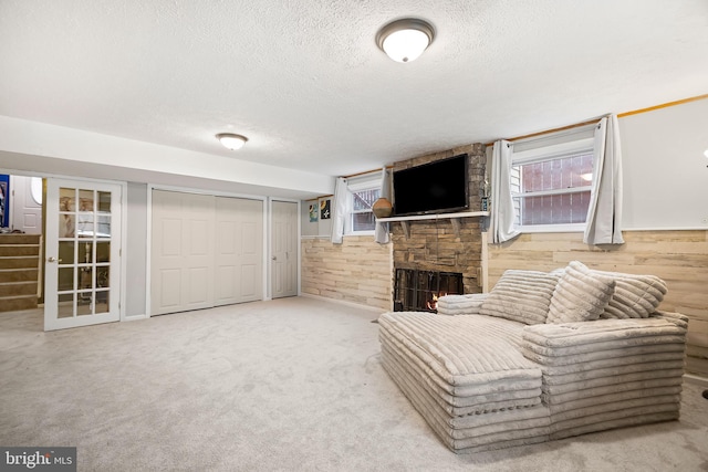 unfurnished room featuring carpet floors, a textured ceiling, wood walls, and a fireplace