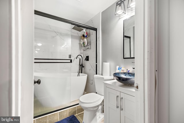 bathroom featuring toilet, a shower with shower door, and vanity