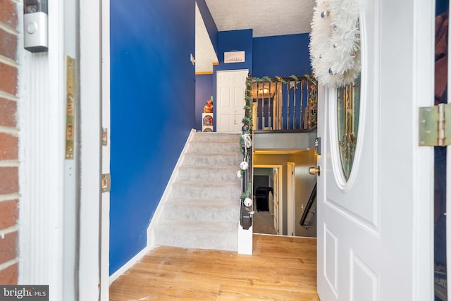 stairway featuring hardwood / wood-style flooring and a textured ceiling