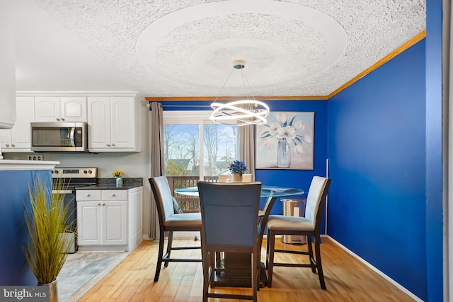 dining area featuring a notable chandelier, light hardwood / wood-style flooring, and ornamental molding