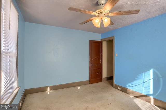 unfurnished bedroom with ceiling fan, carpet floors, and a textured ceiling