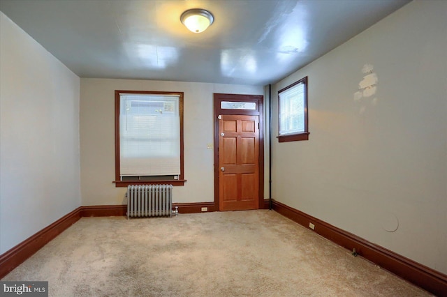 unfurnished room featuring carpet flooring and radiator heating unit