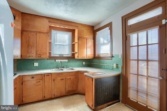 kitchen featuring backsplash, sink, and a textured ceiling