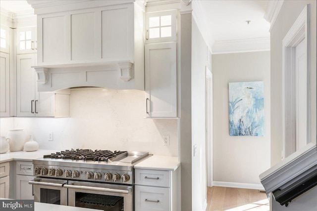 kitchen with custom range hood, ornamental molding, light hardwood / wood-style flooring, decorative backsplash, and range with two ovens