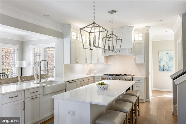 kitchen featuring white cabinets, a kitchen bar, and a kitchen island with sink