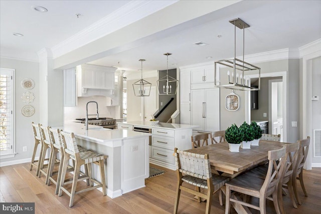 dining room with sink, light hardwood / wood-style flooring, and a wealth of natural light