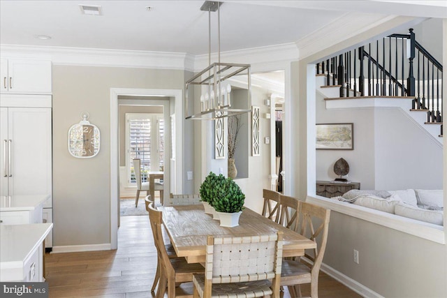 dining room with ornamental molding, light hardwood / wood-style flooring, and an inviting chandelier