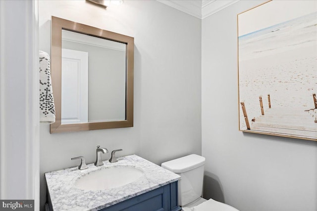 bathroom featuring toilet, vanity, and crown molding