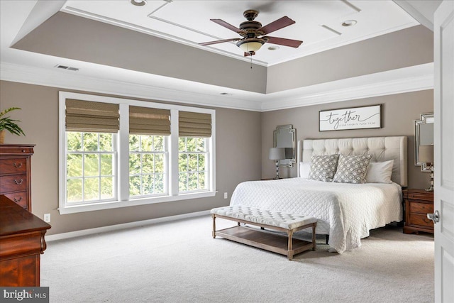 carpeted bedroom featuring ceiling fan, ornamental molding, and a raised ceiling