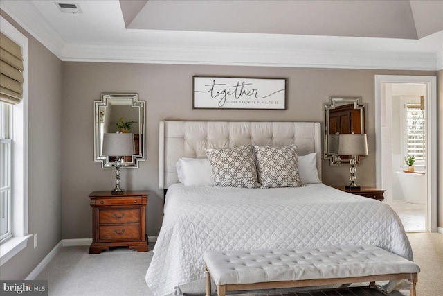 carpeted bedroom with connected bathroom and ornamental molding